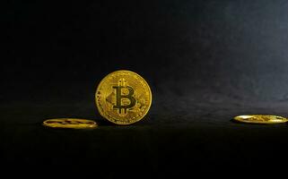 Golden bitcoin, Bitcoin lay on a black table with black background and ray of light. photo