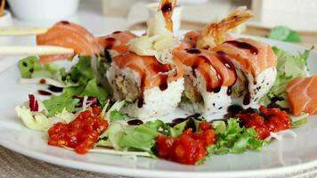 View of fusion salmon sushi rolls with sauce on white plate. Healthy and fusion japanese food style concept video