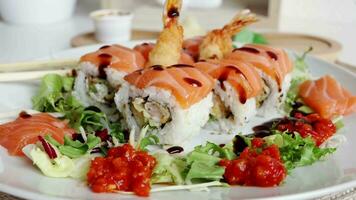 ver de fusión salmón Sushi rollos con salsa en blanco lámina. sano y fusión japonés comida estilo concepto video