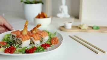 View of fusion salmon sushi rolls with sauce on white plate. Healthy and fusion japanese food style concept video