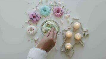 superiore Visualizza tazza di caldo cioccolato. marshmallows nel boccale con cacao. colorato ciambelle su un' bianca tavolo circondato con candele video