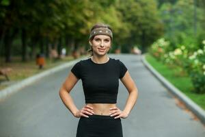 Sporty young woman in sportswear doing stretching exercises outdoors. Portrait of a young girl doing sport in the park. photo