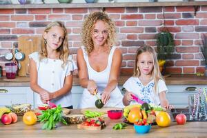 madre y hijas Cocinando juntos en el cocina. sano comida concepto. retrato de contento familia con Fresco batidos foto