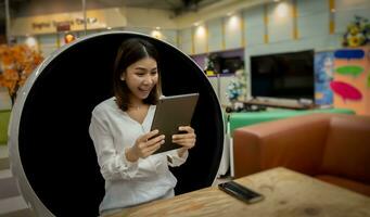 Beautiful office lady was surprised about her sales this month while sitting on a modern round chair in the living room. photo