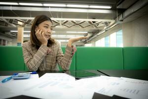 hermosa asiático mujer de negocios mira a el abierto mano con Copiar espacio con un emocionado expresión en su oficina. foto