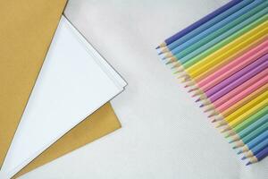 Top right view, Group of color pencild laying in row striaght line made by pencil tips on white and paper background, close up, Color pancils, copy space, Pastel color concept, Education concept. photo