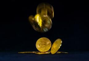 Golden bitcoin on pile, Bitcoin falling with black background. Currency exchange and Digital money concept. photo