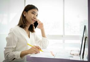 Beautiful asian businesswoman talking to her boss about today's photo