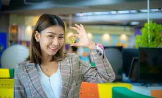 Beautiful asian business woman holding bitcoin while looking to photo