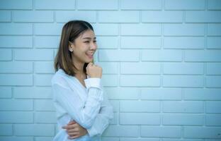 hermosa asiático negocio mujer cruzado brazos transmitir un sentido de confianza y preparación a tomar en ninguna desafío, digital marketing. foto