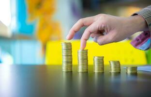 Business woman touching the second pile of coins from the left on black desk, Digital money concept, Finance and management concept, Business for future concept. photo