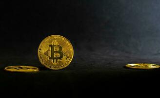 Golden bitcoin, Bitcoin lay on a black table with black background and ray of light. photo
