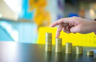 Business woman touching the second pile on black table, Finance and management concept, Concept of saving money for the future. photo