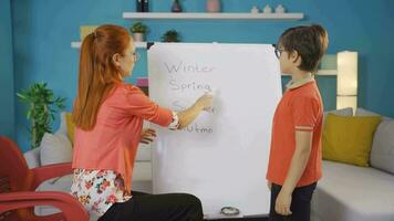 Teacher teaching her boy student the Seasons. video