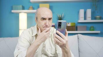 il vecchio uomo utilizzando il Telefono prende triste e emotivo. video