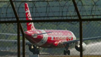 PHUKET, THAILAND FEBRUARY 10, 2023 - Airbus A320, HSBBW of AirAsia departure at Phuket airport. View through the airport fence, plane speeding up for takeoff video