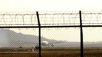 passageiro avião aterrissagem e frenagem. fumaça a partir de tocante a chassis dentro a luz de fundo. manhã voar A chegar às alvorecer video