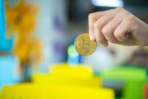 Hand holding golden bitcoin in close up shot, Digital money concept, Finance and management concept, Business for future concept. photo