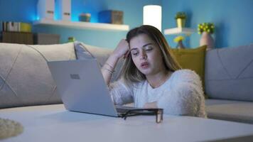 Sleepy and exhausted young woman looking at laptop. video