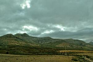 empty mysterious mountainous landscape from the center of the Canary Island Spanish Fuerteventura with a cloudy sky photo