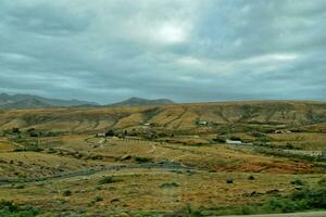 empty mysterious mountainous landscape from the center of the Canary Island Spanish Fuerteventura with a cloudy sky photo