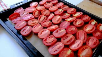 Delicious red tomatoes. man hands putting tomatoes to tray for drying, closeup video