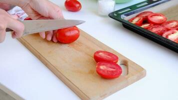 schließen oben Aussicht von Frau Hände Schneiden Tomaten mit ein Köche Messer, langsam Bewegung video