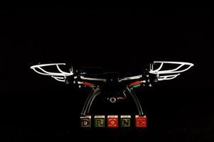 Drone carrying blocks on dark background photo