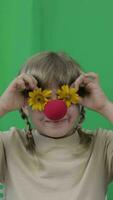 un niña con un rojo nariz y participación amarillo flores en frente de su ojos video