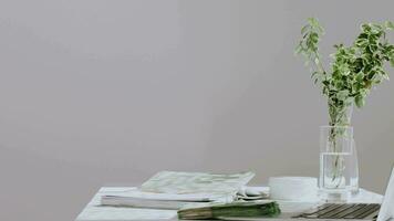 a laptop and a vase of flowers on a desk video