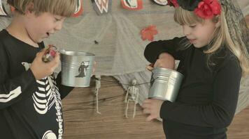 two children in halloween costumes holding buckets of candy video