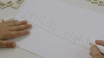 un niño escritura en un pedazo de papel con un marcador video