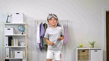 a boy in a white shirt and shorts is standing in a room video