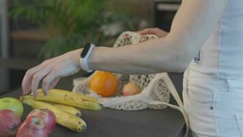 en kvinna är innehav en väska av frukt och grönsaker video