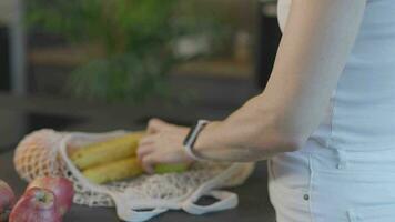 a woman is holding a bag of fruit and vegetables video