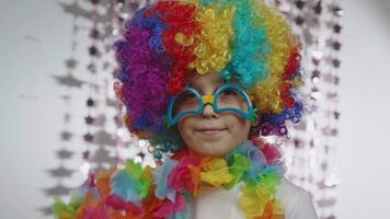 a young boy wearing a colorful wig and glasses video