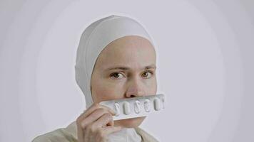 uma mulher dentro uma branco hijab segurando uma comprimido video