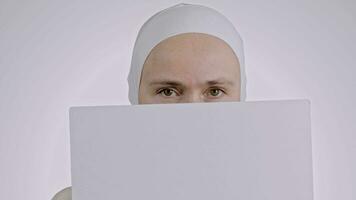 ein Frau im ein Weiß Hijab halten ein leer Blatt von Papier video