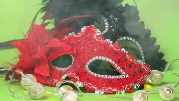 ein rot und schwarz Karneval Maske mit ein rot Bogen auf das Grün Hintergrund video