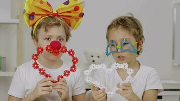 zwei Kinder tragen Party Bogen und Clown Brille halten Herz geformt Papier video