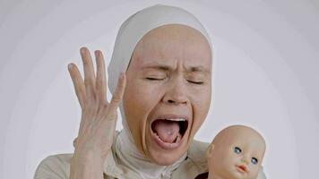 uma mulher com uma branco hijab segurando uma boneca video