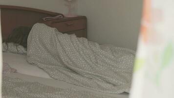 un niño es dormido en un cama cubierto en mantas video