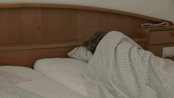 uma criança é dormindo dentro uma cama coberto dentro cobertores video