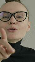 a woman wearing glasses and a black turtle neck video