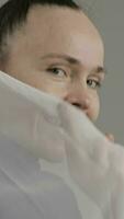 a woman is holding a white cloth over her face video