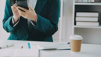 Businesswoman using calculators for do math finance on wooden desks in office and business working background, tax, accounting, statistics, and analytic research concept video