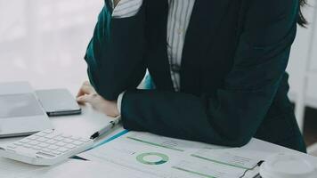 mujer de negocios utilizando calculadoras para hacer matemáticas Finanzas en de madera escritorios en oficina y negocio trabajando fondo, impuesto, contabilidad, Estadísticas, y analítico investigación concepto video