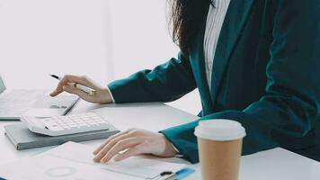 Businesswoman using calculators for do math finance on wooden desks in office and business working background, tax, accounting, statistics, and analytic research concept video