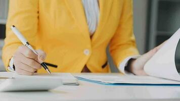Businesswoman using calculators for do math finance on wooden desks in office and business working background, tax, accounting, statistics, and analytic research concept video