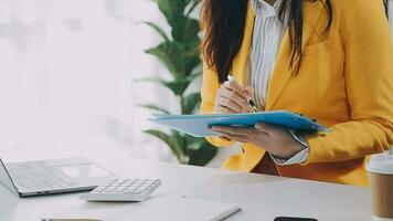 Businesswoman using calculators for do math finance on wooden desks in office and business working background, tax, accounting, statistics, and analytic research concept video